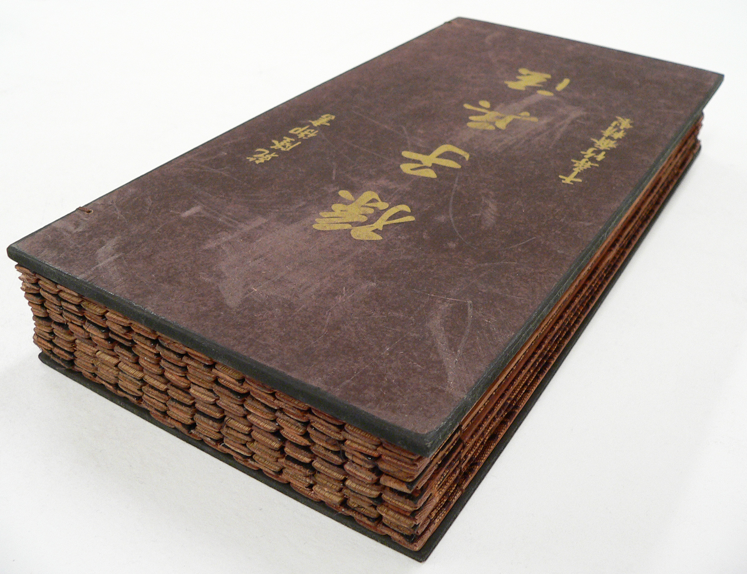 Libro de bambú chino cerrado, representando El arte de la guerra de Sun Tzu, fundamento de la estrategia clásica y las palancas de dominación